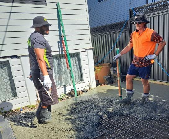 Frezno crew spreading concrete over reinforcing mesh on a residential driveway