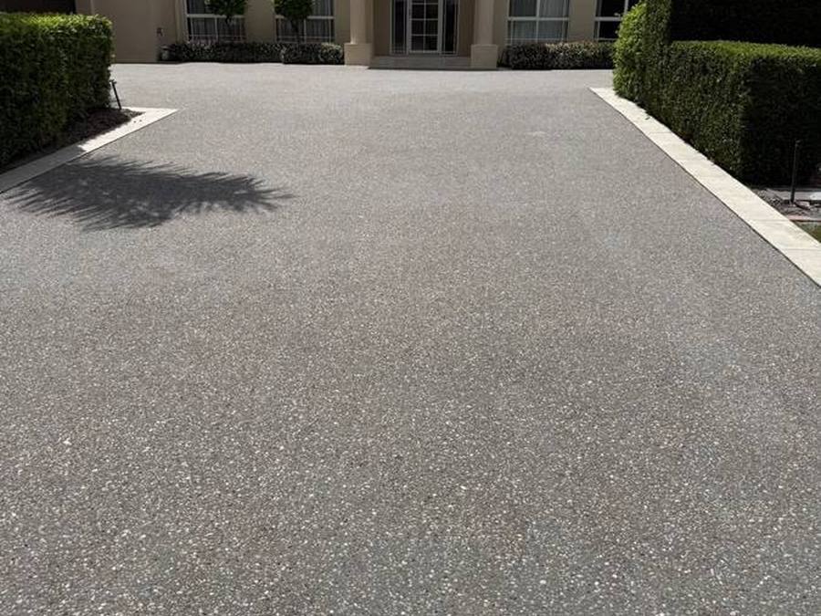 Sweeping exposed aggregate driveway at a two-storey executive home
